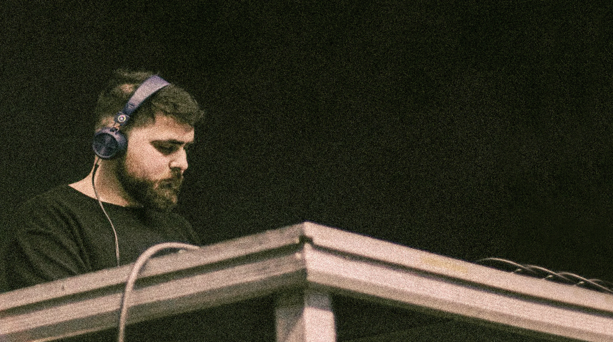 Tensso wearing headphones behind the decks